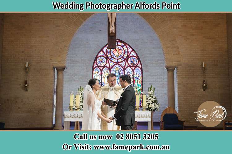 Photo of the Bride and Groom at the Altar with the Priest Alfords Point NSW 2234