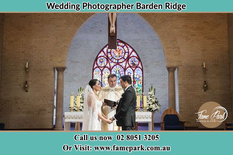 Photo of the Bride and Groom at the Altar with the Priest Barden Ridge NSW 2234