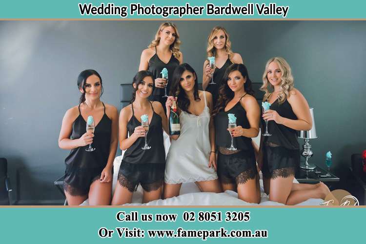 Photo of the Bride and the bridesmaids wearing lingerie and holding glass of wine on bed Bardwell Valley NSW 2207