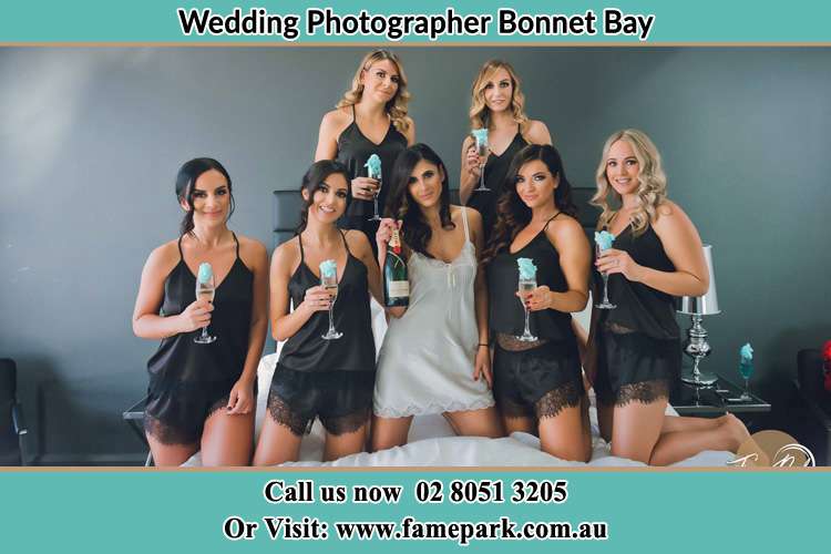 Photo of the Bride and the bridesmaids wearing lingerie and holding glass of wine on bed Bonnet Bay NSW 2226