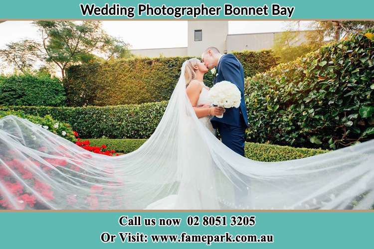 Photo of the Bride and the Groom kissing at the garden