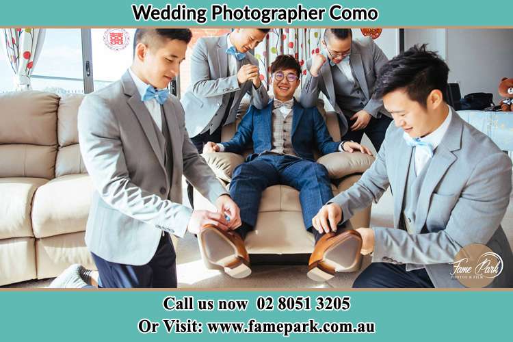 Photo of the Groom helping by the groomsmen getting ready Como NSW 2226