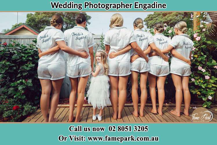 Behind photo of the Bride and the bridesmaids holding flowers near the pool Engadine NSW 2233