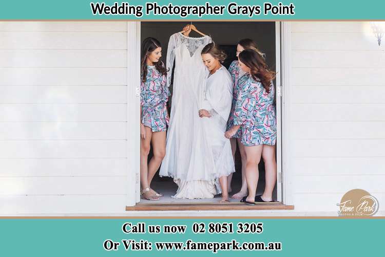 Photo of the Bride and the bridesmaids checking the wedding gown at the front door Grays Point NSW 2232