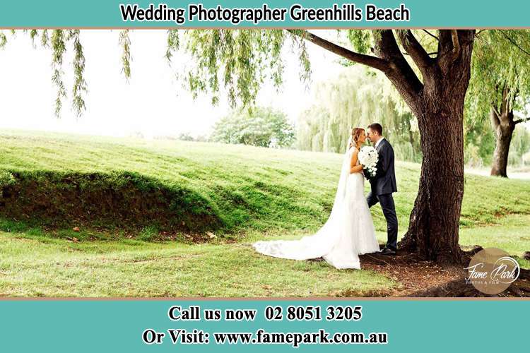 Photo of the Bride and the Groom kissing under the tree Greenhills Beach NSW 2230