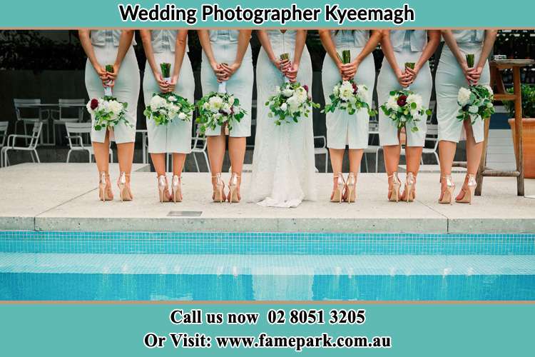 Behind photo of the Bride and the bridesmaids holding flowers near the pool Kyeemagh NSW 2216