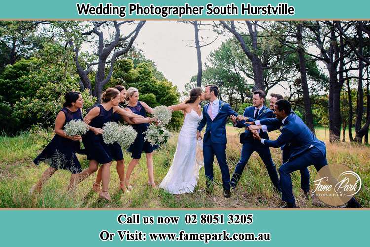 Photo of the Bride and the Groom kissing while teasing by the entourage South Hurstville NSW 2221