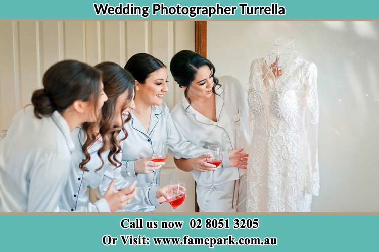 Photo of the Bride and the bridesmaids looking at the wedding gown Turrella NSW 2205